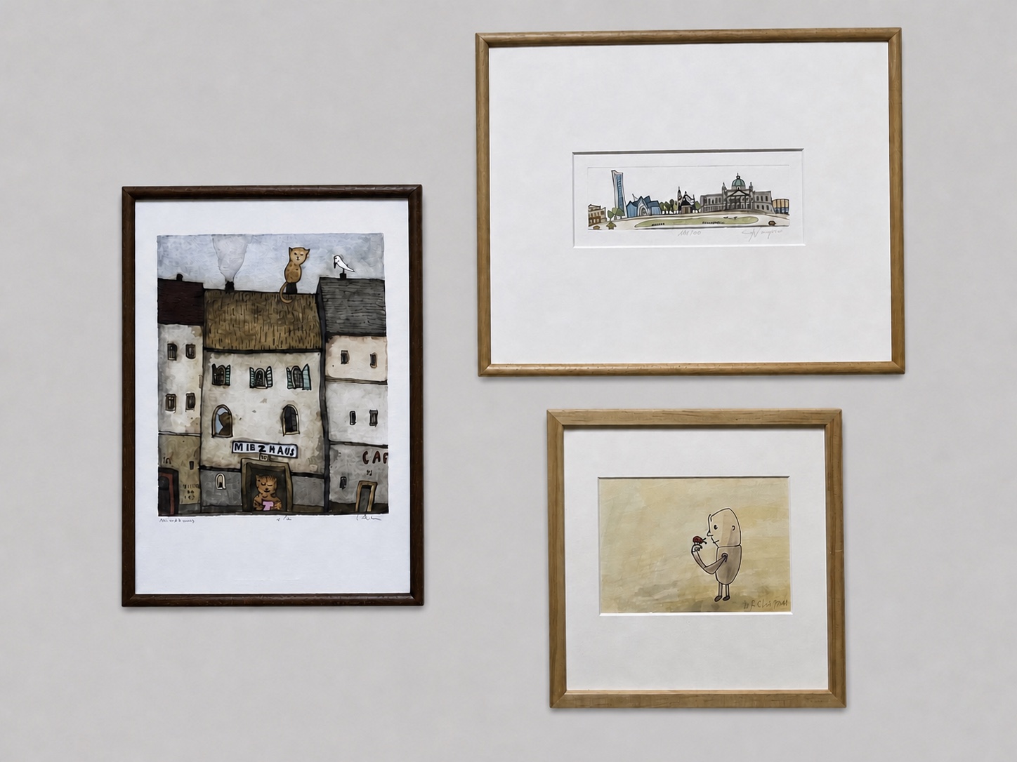 Drei kleine gerahmte Kunstwerke in unterschiedlichen Formaten auf hellem Hintergrund